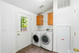 Utility room with door leading out to back deck/yard.