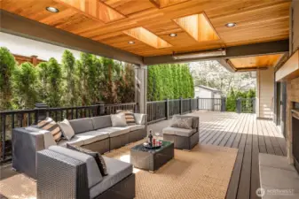 Covered patio with built-in heater and a see-through fireplace, creating a seamless indoor-outdoor living experience
