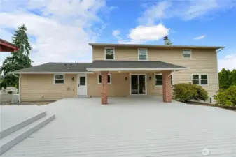 Back view of huge deck looking back to covered area leading into home through slider.