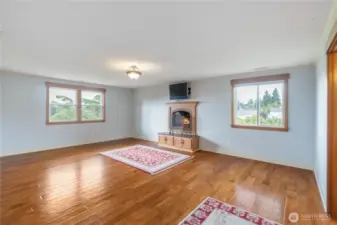 Primary Bedroom with fireplace and built ins. Wood floors with throw rugs matching those downstairs & coming up the stairwell. Great view out windows!