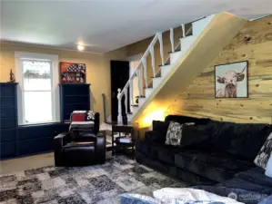 Another angle from living room showcasing accent wall. Door at the bottom of the stairs leads you to remodeled kitchen and the stairs takes you to the three bedrooms and full bath.