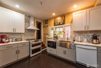 Entry way from the living room leads you to this beautiful modern kitchen, but the original lead windows leaves some of its original charm. Hand wash dishes from the farm house sink overlooking the backyard.