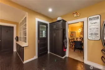 Door on the left side next to the wall of original built-in cabinetry leads you to a full bath. Middle door provides you access to laundry room, mud room and two car garage. Dining room showcased on the far right has a barn door.