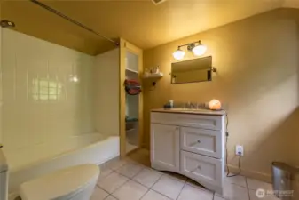 Full bath upstairs with built in linen shelving.