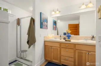 The primary bath with shower, tub, dual vanity with maple cabinet and travertine tile surface. The home also has a second full bathroom.