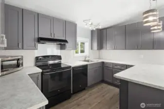 Kitchen features newer appliances, abundant cabinets and vinyl plank flooring.