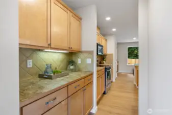 Butler pantry with solid cabinetry and counter space, undermount lighting.