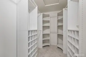 Walk-in closet with installed closet organizer.