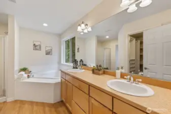 Primary bathroom with dual vanity, corner soaking tub.