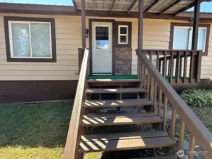 Back entrance from asphalt driveway and carport