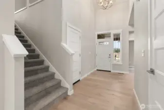 Dramatic entryway greets you with vaulted ceilings and chandelier.