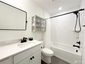 The upper-level full bathroom has double sinks and ceramic tile.