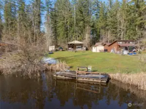 Property has power, private well, and private septic. Pole barn style covered area houses a deck and outbuilding. 2 sheds on either side have concrete floors for dry storage options.