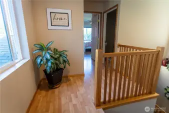 Landing on the upper floor looking towards the second bedroom and 3/4 bath to the right. Behind is the primary and third bedrooms.