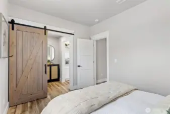 Walkthrough closet off Primary with Knotty Alder barn door and Matte Black hardware.