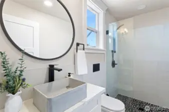 Main bathrrom with full walk-in shower, custom 1/2" thick glass framless shower door, ceramic tile surround & backsplash, concrete vessel sink, concealed tank wall hung toilet and matte black trim.