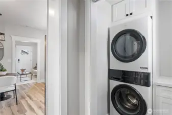 Laundry Room with full sized Laundry Tower with gas dryer, white shaker cabinets, & quartz countertop for folding.