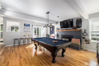 The family room has a fireplace and is currently a game room.