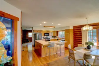 Kitchen with eating bar opens to dining and living rooms, offering a spacious layout and water views.