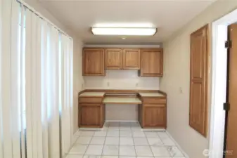 spacious utility room with tile flooring, build-in cabinets, and countertop workspace