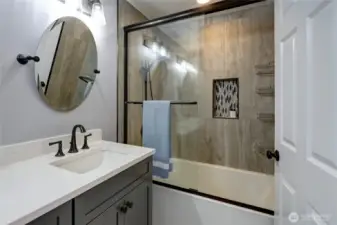 Beautiful primary shower with glass doors.