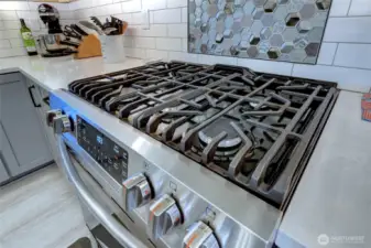 Gas range, convection oven and beautiful tile back-splash.
