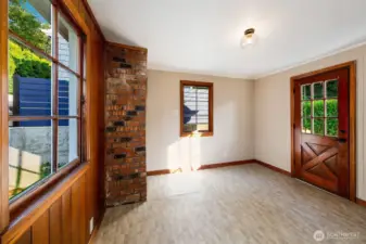 Sunlight filters through original divided-light windows, casting warmth across this charming bonus room with brick accents and Dutch door access. Ideal as a mudroom, creative studio, or office with a garden view, it offers both character and utility in a home already rich with history and potential.