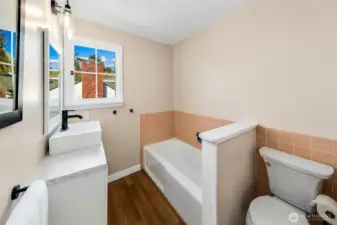 With its vintage tile wainscoting, updated vanity, and peek-a-boo water views, this second bath blends retro character with modern touches. Natural light pours in, making this an inviting spot for a morning soak or a post-beach refresh—part of the home’s layered charm in this storied corner of Browns Point.
