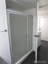 GLASS DOOR ENTRY TO SHOWER STALL.