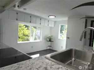 NEW KITCHEN COUNTERS, SINK, FAUCET & APPLIANCES. DINING AREA WINDOW FACES SOUTH AND EAST.