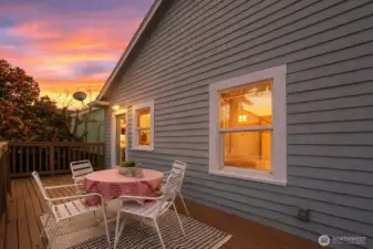 Large deck spans the width of the house with stairs down to the backyard.