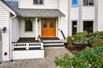 Covered front porch with handsome double doors and a paver walkway that elevates the entry experience. A sheltered landing makes it easy to greet guests, accept deliveries, and transition inside comfortably.