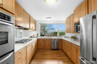 Well-maintained kitchen, complete with a newer gas cooktop, stainless steel appliances, and breakfast bar