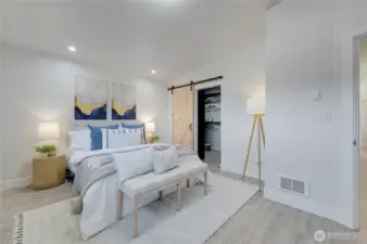 Primary bedroom showing barn door and walk-in closet