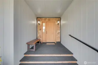 Covered front porch with sconce lighting and beautiful custom door (both sides open)