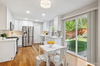 Open-concept kitchen with sliding door to fully-fenced backyard.