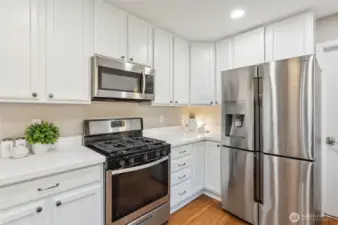 Stainless steel appliances & a 5-burner gas range.