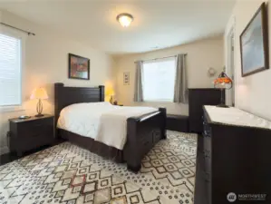 The primary bedroom is spacious and has plenty of light thanks to an added window and custom blinds.