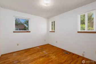 Second bedroom has lots of windows resulting in great lighting! This room also features hardwood floors.