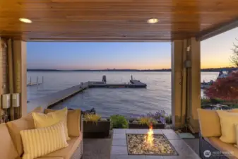 Covered outdoor living space offers the perfect spot to gather around the fire pit, listen to the waves, and enjoy shoreline views - day or night.