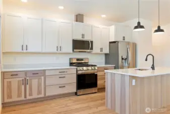 Lovely contrast of lower hickory cabinets with white maple uppers. Sparkling quartz countertops complete with gas range, all brand new appliances.