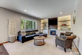 Spacious main floor family room with custom shelving, gas fireplace and a large picture window overlooking the backyard. TV can stay!