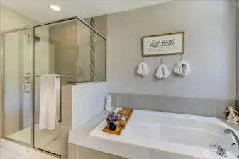 Shower has a shampoo ledge and beautiful tile work.