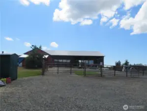 Prominent gated entry looking up towards the 66x100 (6,600 SF) covered semi-enclosed horse arena.