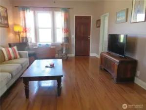Front entry door shown here. New hardwood floor. Sylish ceiling fan in this room.