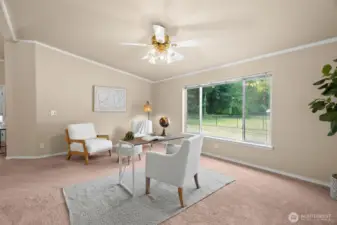 A spacious flex room with a large picture window brings in abundant natural light and views of the property.