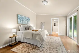 The spacious primary bedroom features sliding glass doors to the backyard and direct access to a private ensuite bathroom—creating a relaxing retreat with comfort and convenience in mind.