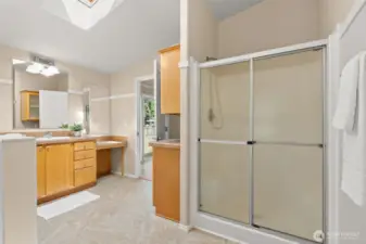 The ensuite bath features ample storage with built-in cabinetry and a convenient vanity, along with a separate walk-in shower.
