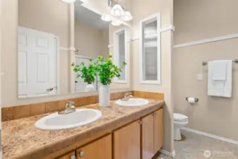 The hall bath features double sinks with great storage, a shower/tub combo, and a skylight that brightens the room with natural light—perfect for busy mornings and shared routines.