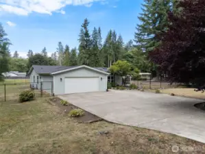 A spacious driveway and attached two-car garage provide plenty of parking and convenience, all set within a partially fenced property surrounded by nature. Welcome home to comfort, privacy, and room to grow.